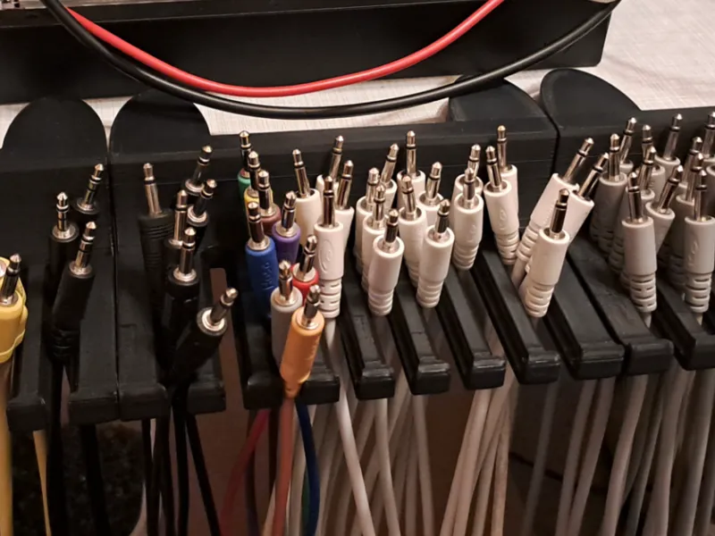 Table edge holder for Eurorack patch cables