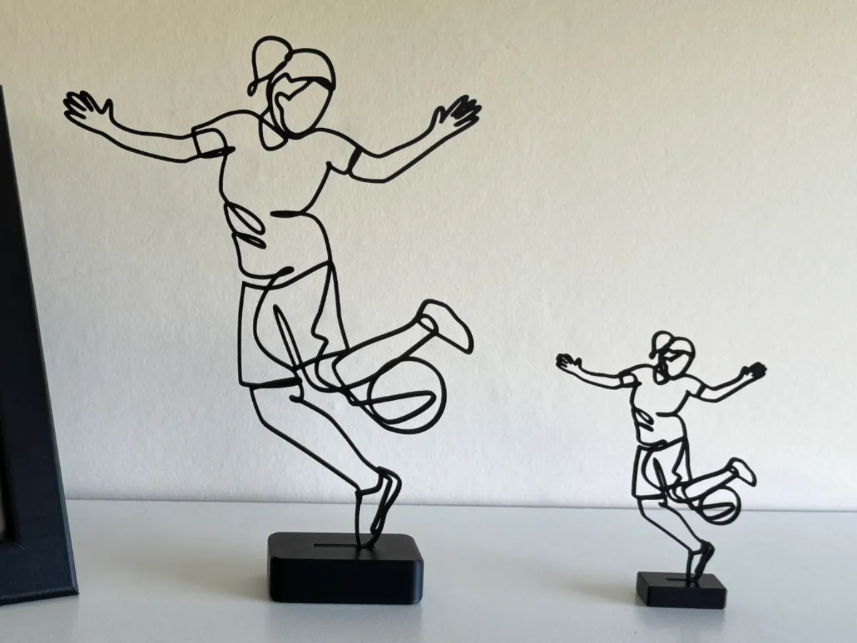 Sculpture filaire footballeuse en action