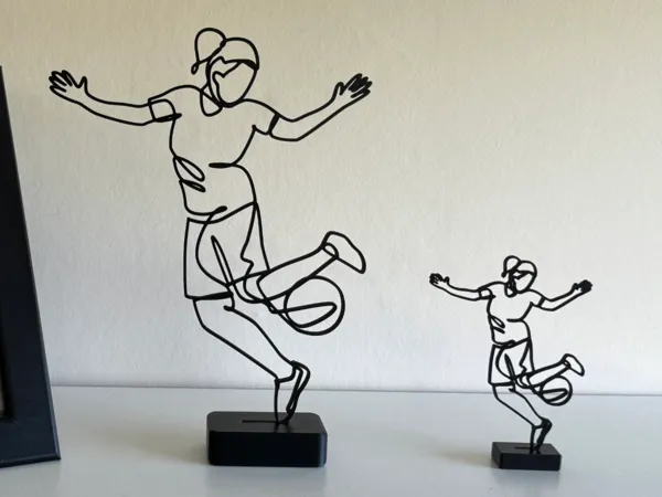 Sculpture filaire footballeuse en action