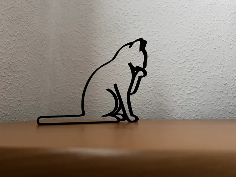 Katzensilhouette sitzend- leckt die Pfote