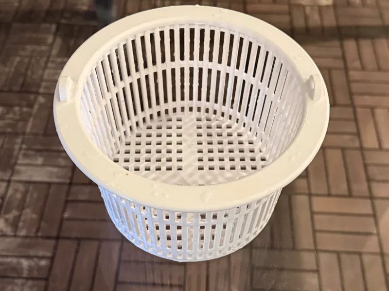Swimming pool skimmer basket with handle