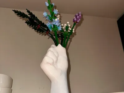 Hand holding flowers vase