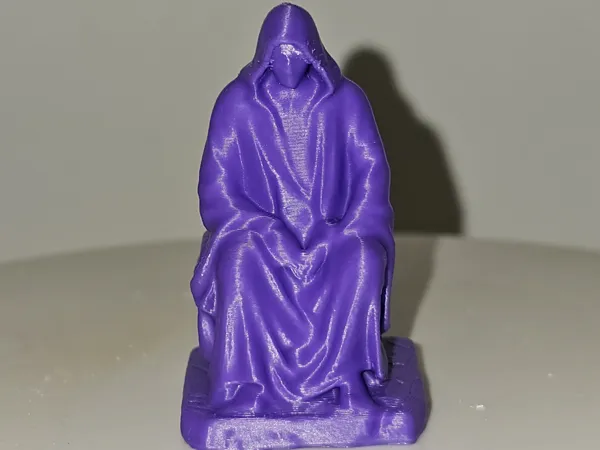 Figurine homme encapuchonné assis