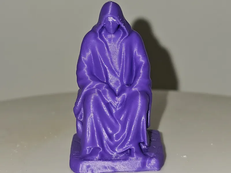 Hooded man sitting on rock