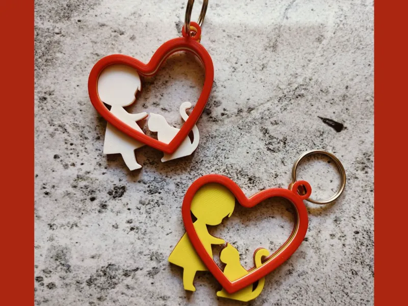 Heart-shaped keychain with girl and cat