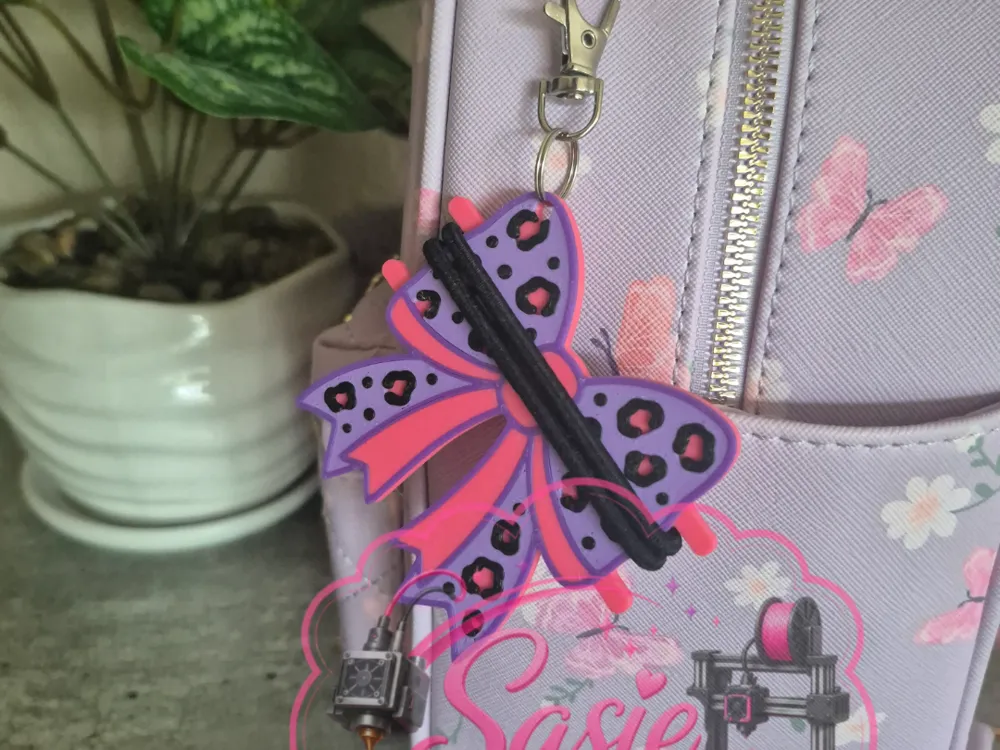 Accesorio para sujetar ligas de cabello: Cheetah Print Bow Hair Tie Holder Keychain. Referencia del modelo original.