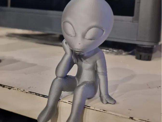Bored Alien sitting on curb (Gelangweilter Alien)