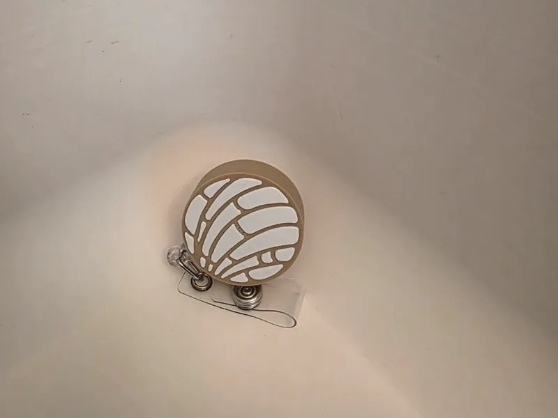 Concha badge reel cover