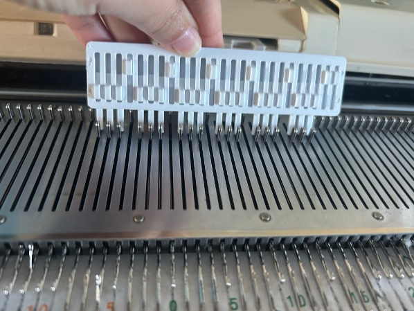 Adjustable needle pusher for Machine knitting