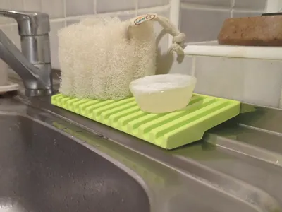 Slanted sponge holder for stepped kitchen sinks