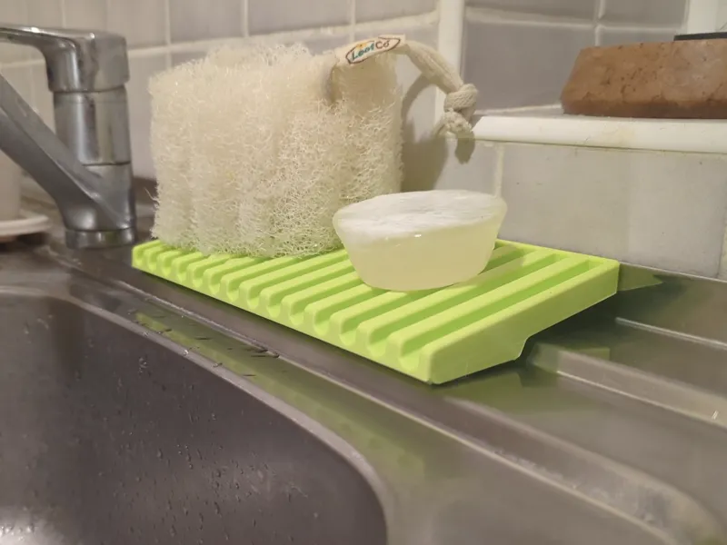 Slanted sponge holder for stepped kitchen sinks