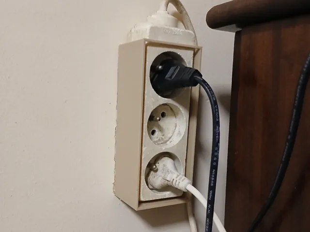 Wall-mounted extension cord holder
