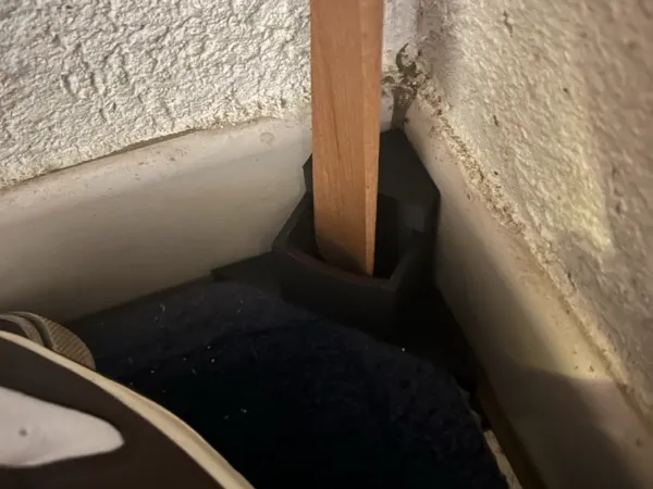 Shoehorn holder for carpet edge corner