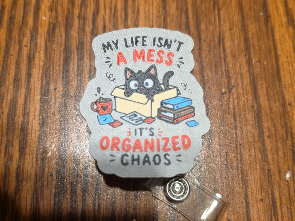Tapa o cubierta: Organized Chaos Badge Reel/Magnet. Referencia del modelo original.