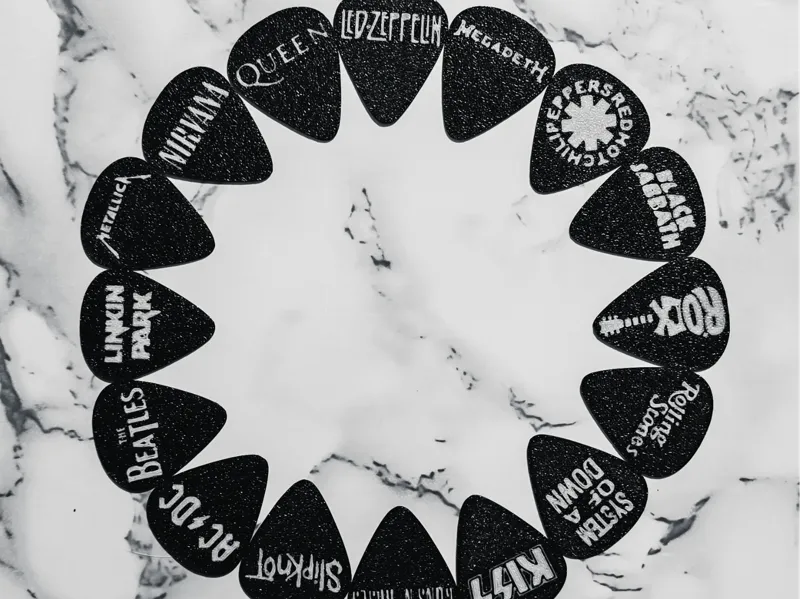 Púas de guitarra con nombres de bandas