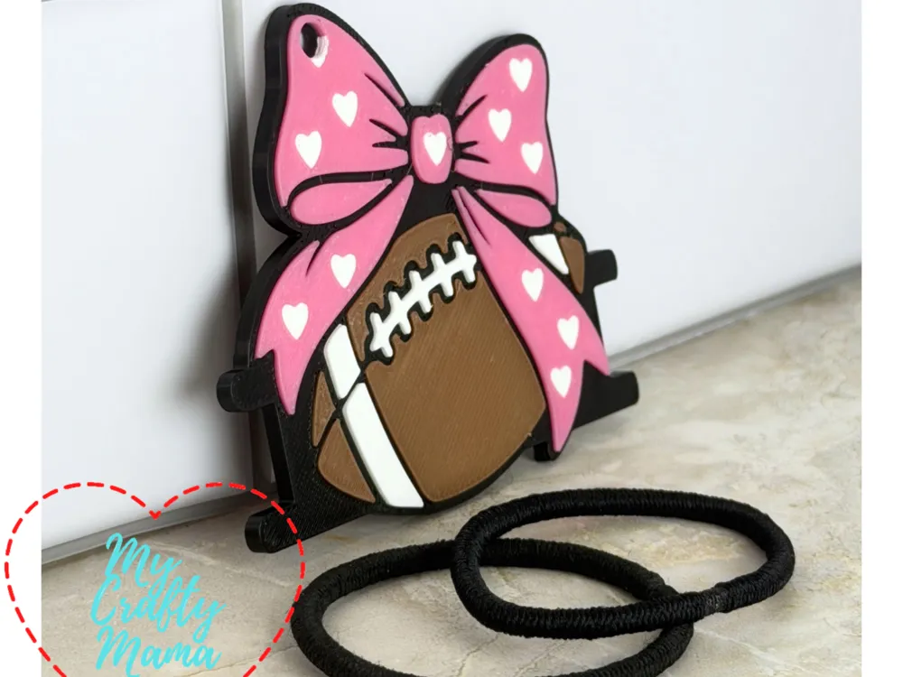 Accesorio para sujetar ligas de cabello: Football bow hair tie keychain. Referencia del modelo original.