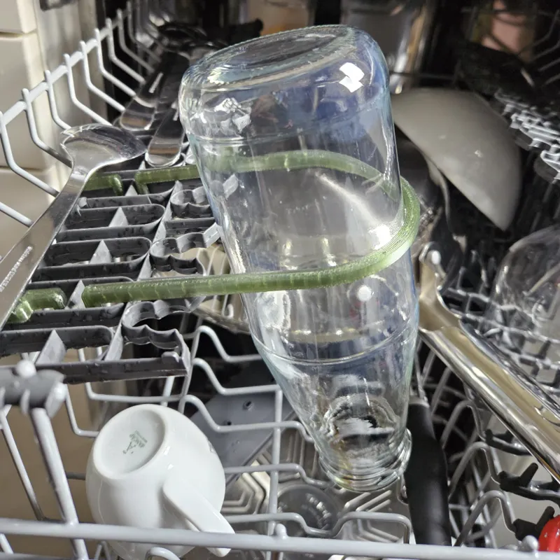 Bottle support or clamp for dishwasher