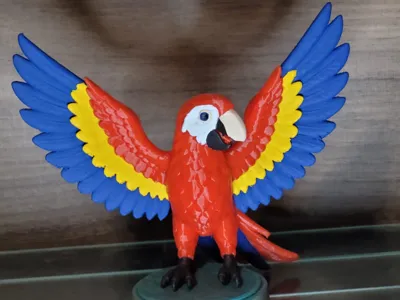 red macaw with open wings on a base