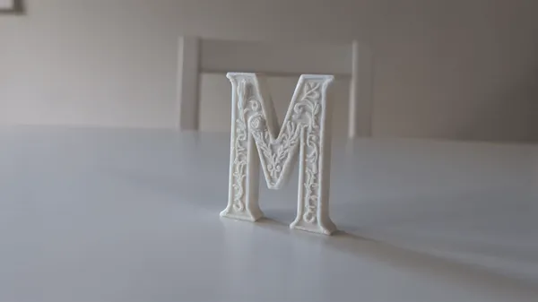 Lettre décorative M à motifs floraux