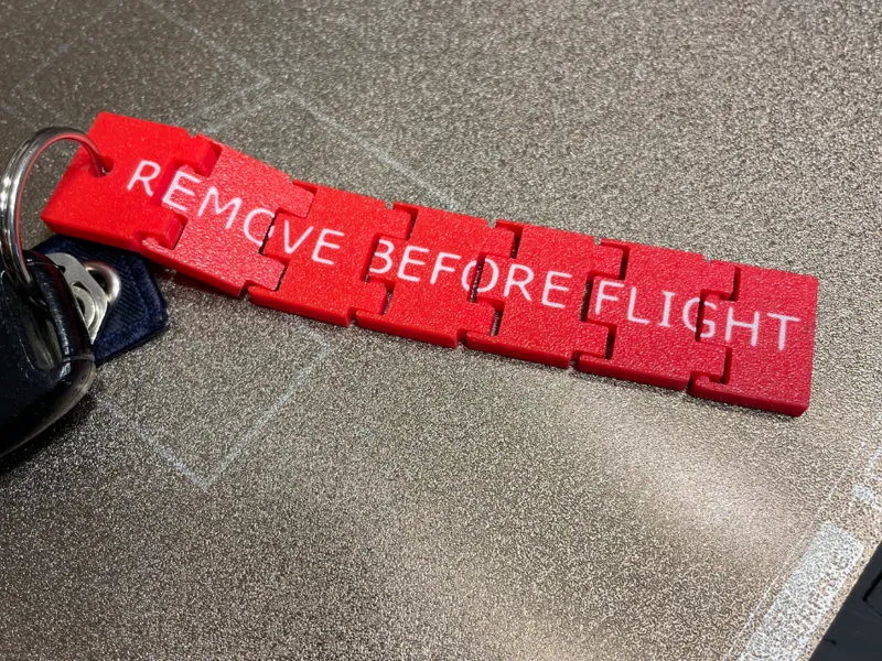 Hinged Flexi Remove Before Flight Keychain Tag