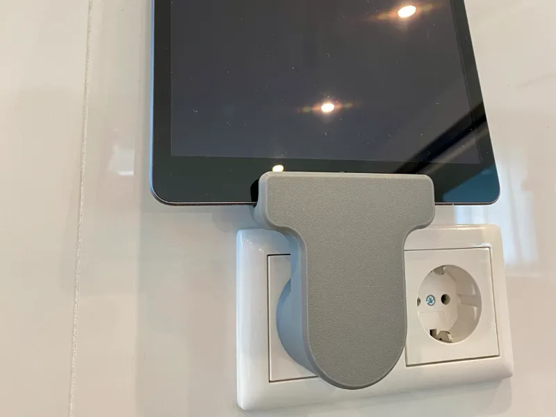 Universal tablet /phone holder for a power socket