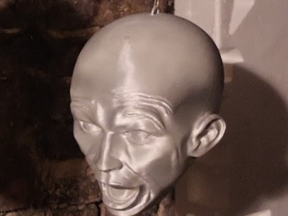 A life-sized screaming head with a hook