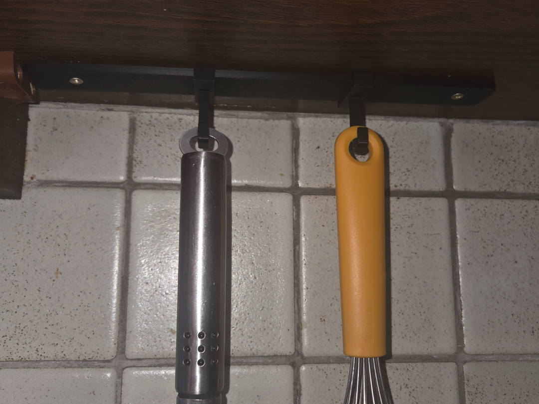 sliding under cabinet hook for rail system