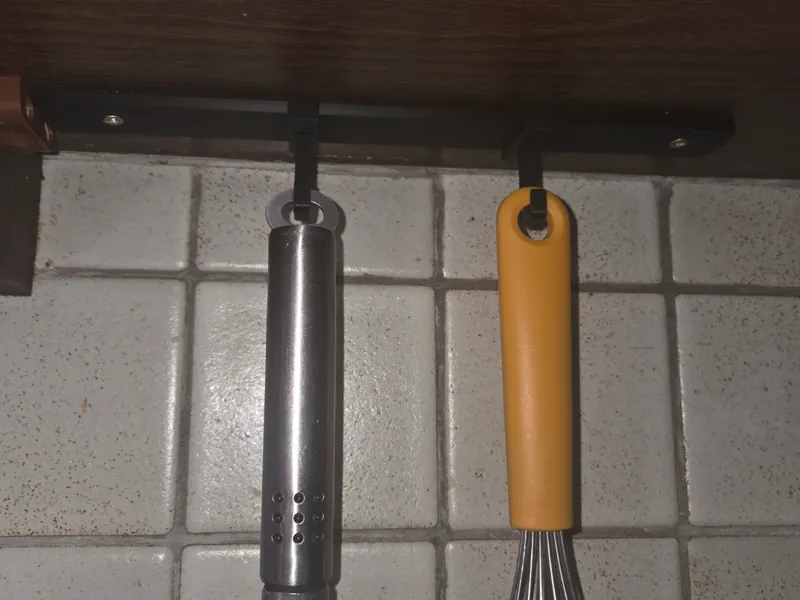 sliding under cabinet hook for rail system