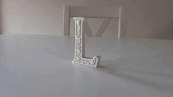 Lettre décorative L à motifs floraux