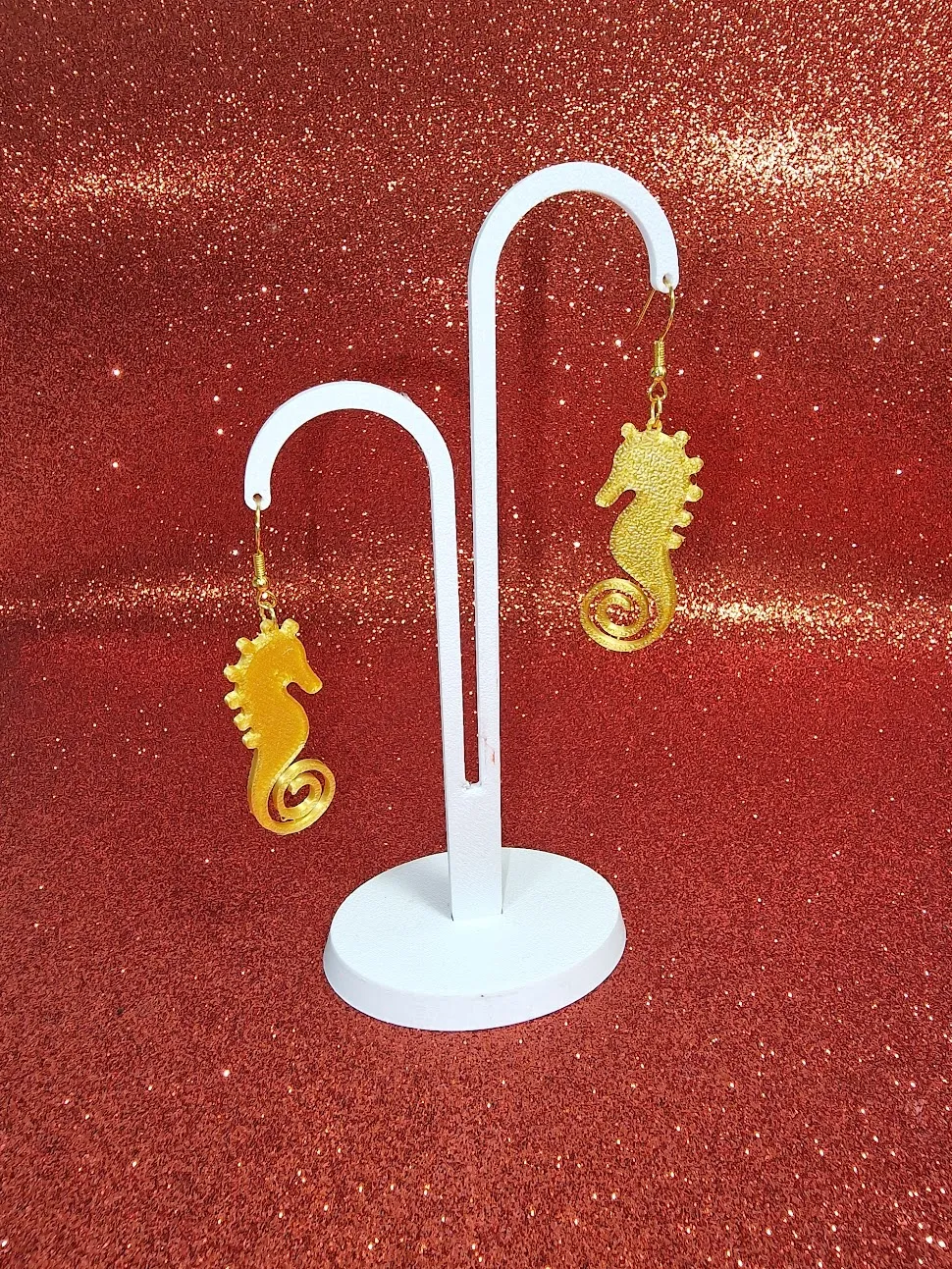 A gold seahorse earring view 3
