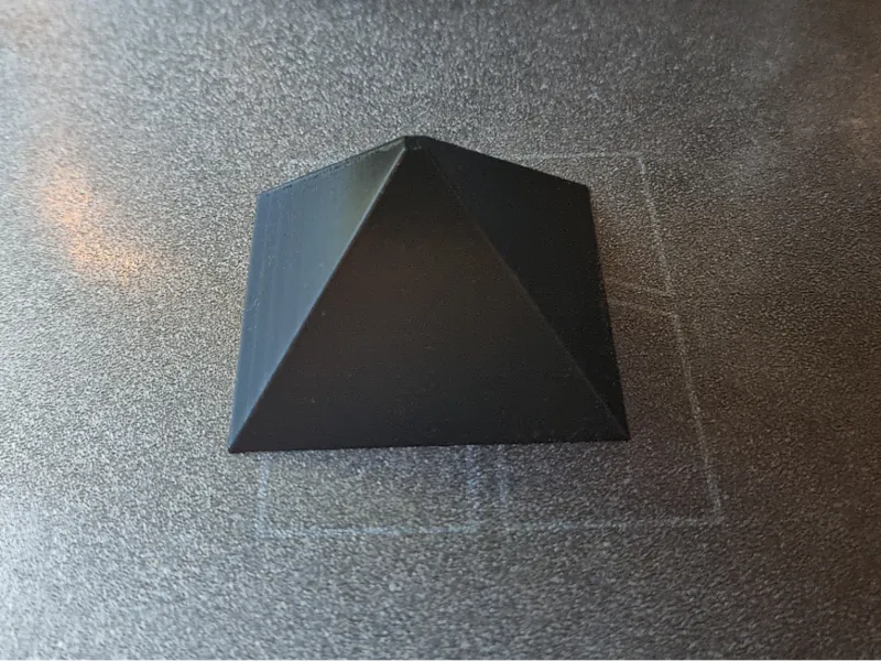 Painter Woodworker finishing pyramid with flat top