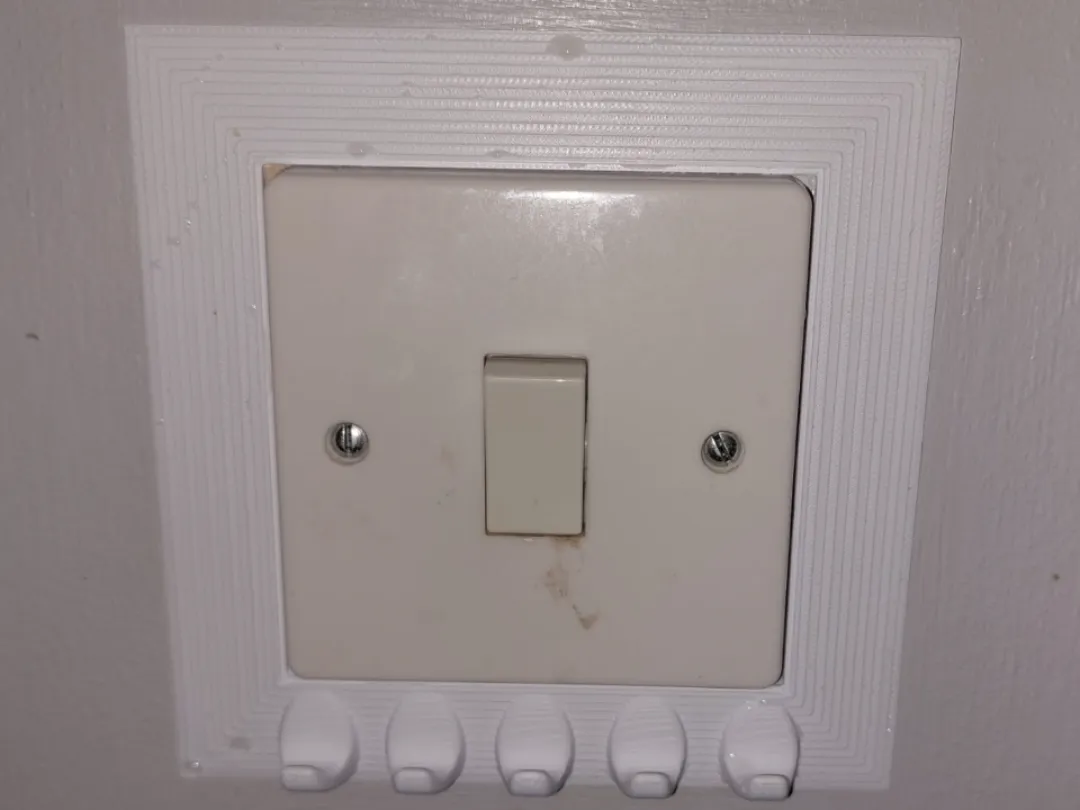 Plaque d'interrupteur avec crochets porte-clés