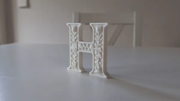 Lettre "H" décorative sur pied, style plâtre floral