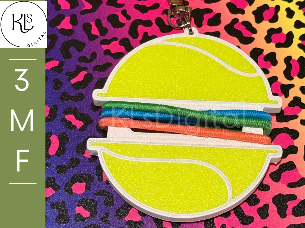 Accesorio para sujetar ligas de cabello: Tennis Ball Hair Tie Holder. Referencia del modelo original.