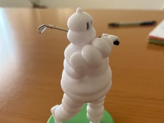 Bibendum Michelin playing golf