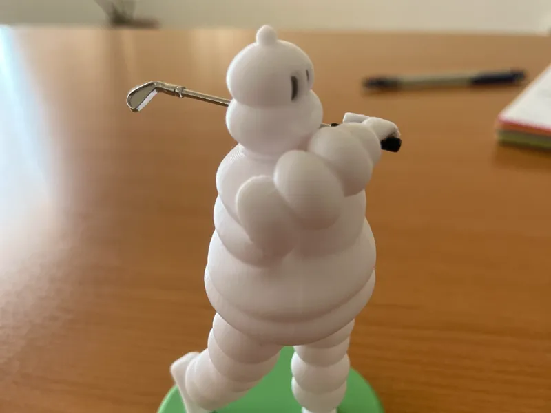 Bibendum Michelin playing golf