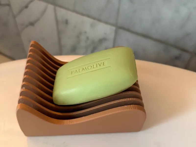 Soap dish with a flowing form, self draining