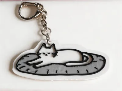 Cute cat sleeping on blanket keychain
