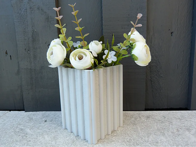 Square ribbed vase- with fuzzy skin accents .
