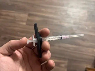 Syringe plunger holder