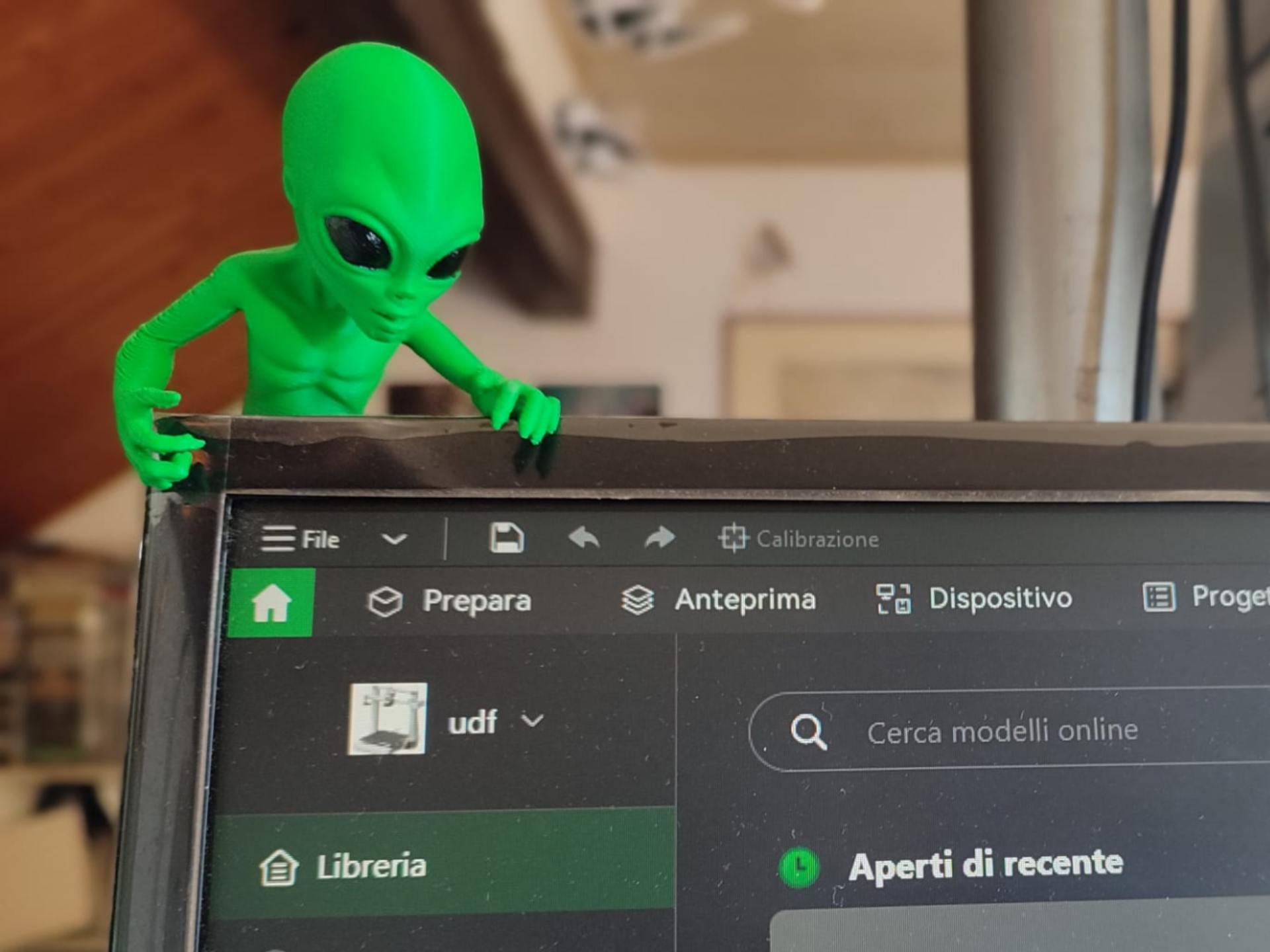Alieno verde che spia il monitor