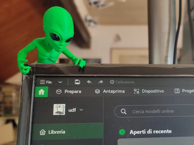 Alieno verde che spia il monitor