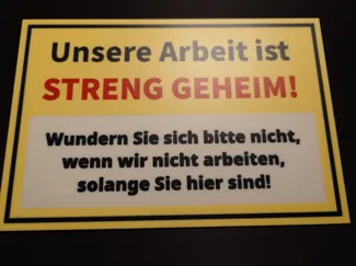 Lustiges Schild: Unsere Arbeit ist streng geheim!