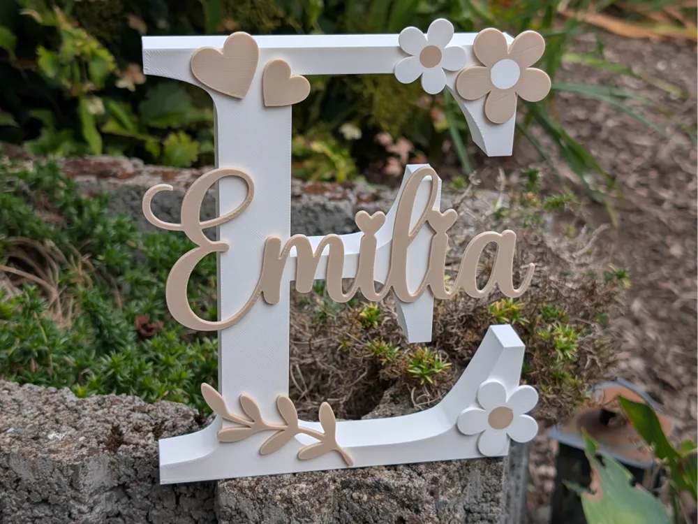 Letrero o emblema decorativo: Emilia. Referencia del modelo original.