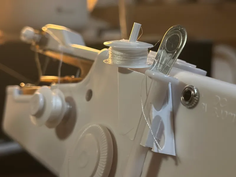 Side-mounted storage for a handheld sewing machine
