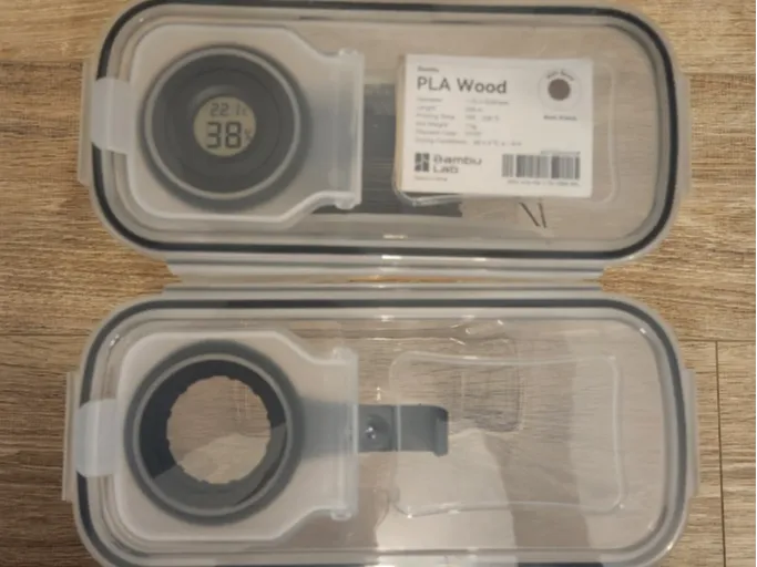 Filament container label clip and hygrometer mount