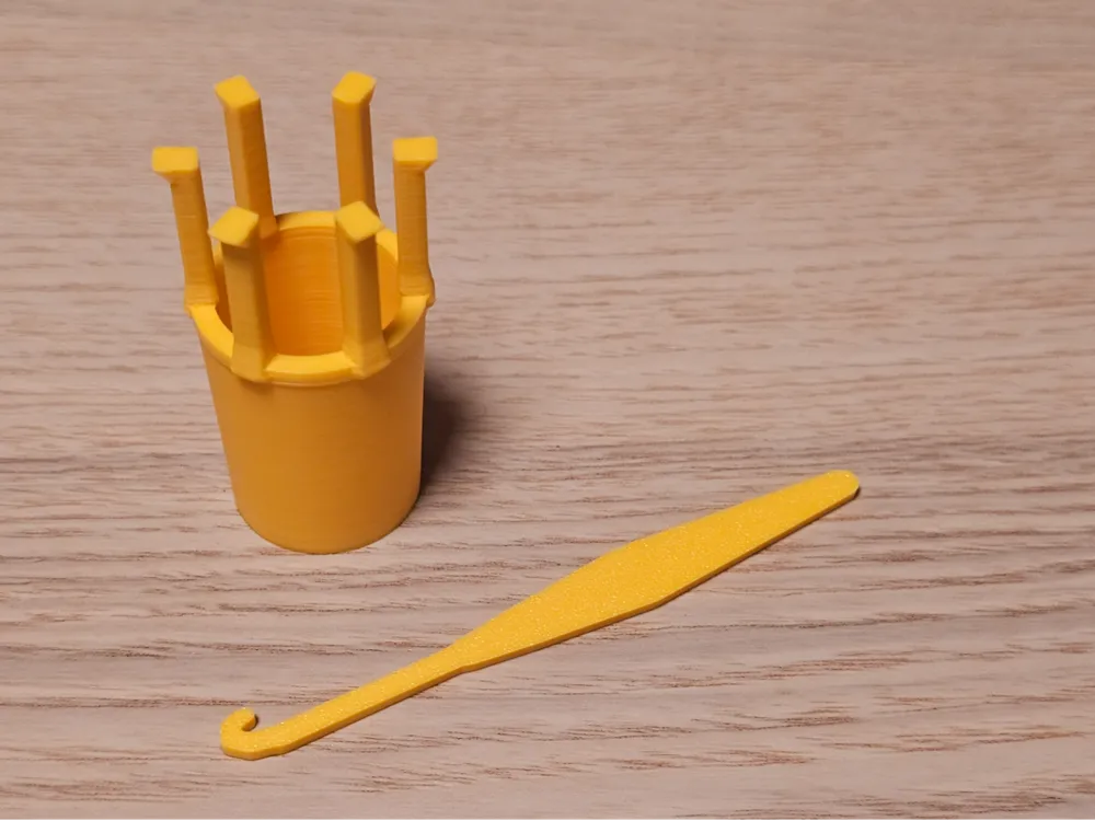 Letrero o emblema decorativo: 6-Peg Rubber Band Loom & Hook with Mini Knitter. Referencia del modelo original.