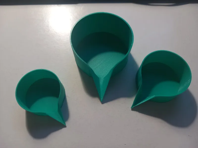 Measuring feeder cup with a spout