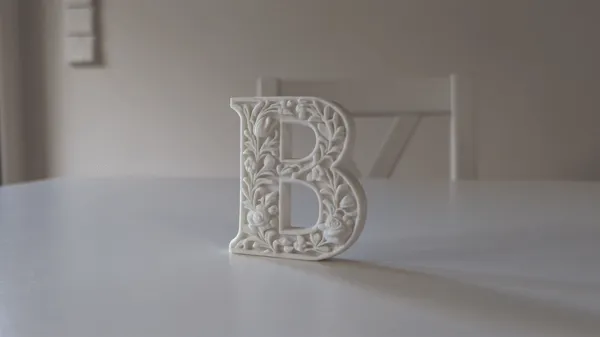 Lettre B décorative sur socle, style plâtre floral